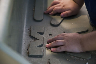 Cropped hands of kid on metal