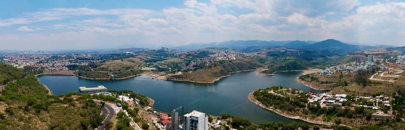 High angle view of city by lake against sky