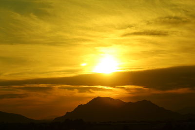 Scenic view of silhouette mountains against romantic sky at sunset