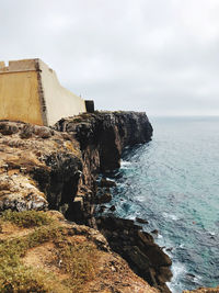 Rock formations by sea against sky