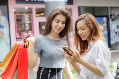 Portrait of happy woman holding camera at store