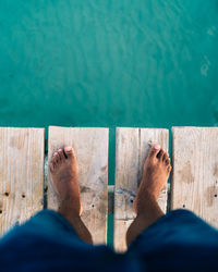 Low section of man relaxing on swimming pool