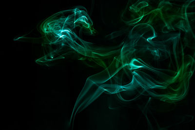 Green smoke against black background