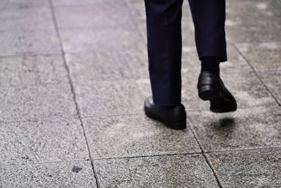 Low section of man walking on footpath