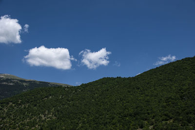 Low angle view of mountain against blue sky