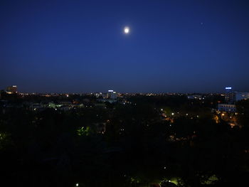 Illuminated cityscape against sky at night