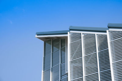 Low angle view of modern building against clear blue sky