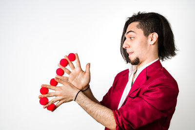 Side view of young man standing against white background