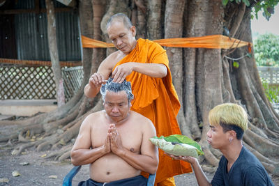 Happy friends sitting on a man holding food