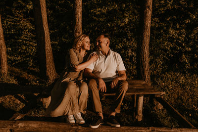 Portrait of young woman sitting in forest