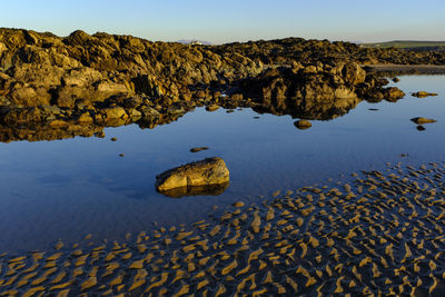 Scenic view of lake and rock formation against sky