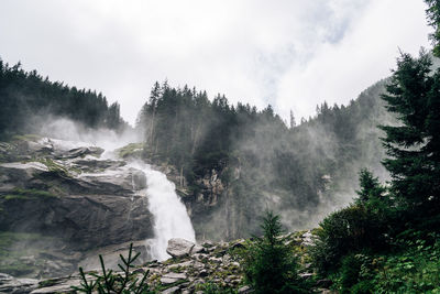 Scenic view of waterfall in forest against sky