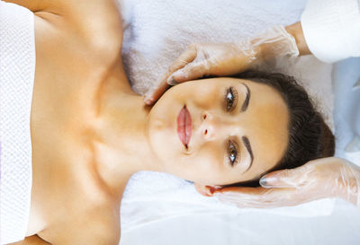 Portrait of woman lying on bed at spa