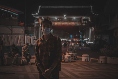 Portrait of young man wearing mask standing outdoors