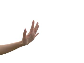 Cropped hand of woman showing stop gesture against white background