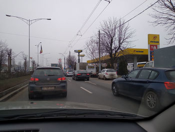 Cars on road against sky in city