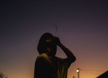 Low angle view of silhouette woman standing against clear sky