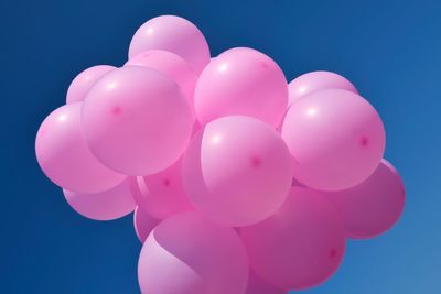 Low angle view of balloons against blue sky