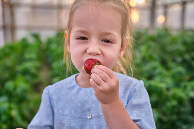 Portrait of young woman holding plant