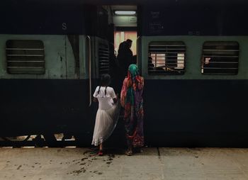 Rear view of woman standing in train