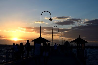 Silhouette people against sky during sunset