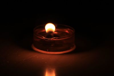 Close-up of lit candle on table