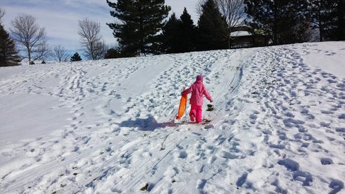 Rear view of girl walking on ski slope