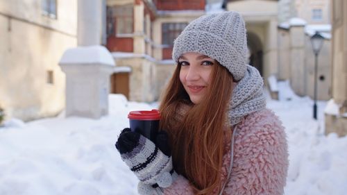 Portrait of young woman drinking in snow