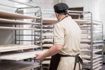 Rear view of man standing in factory