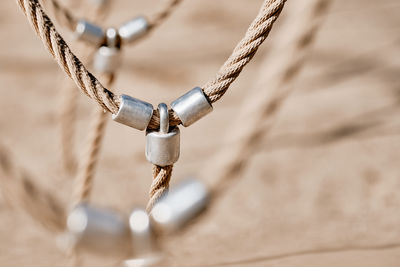 Close-up of rope tied on metal chain