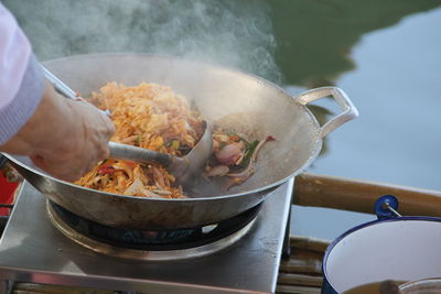 Close-up of person preparing food on barbecue grill