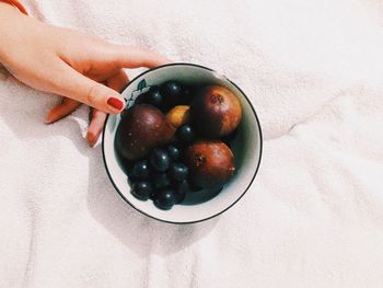 Cropped hand of woman with fruits in bowl