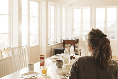 Rear view of woman sitting at table