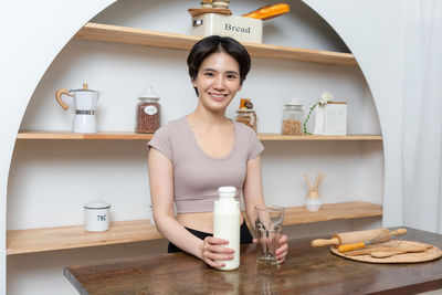 Portrait of young woman sitting on table