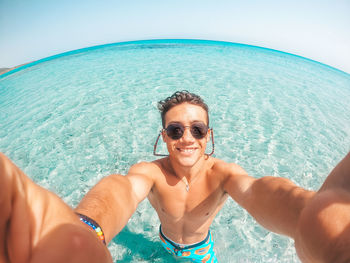 Portrait of smiling woman in sea against sky
