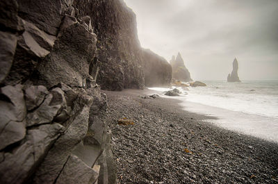 Rock formations by sea against sky