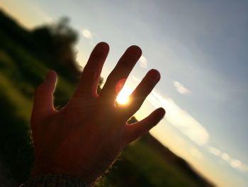 Close-up of hand against sky