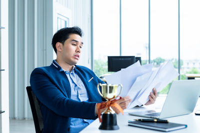 Businesswoman using mobile phone while sitting on table