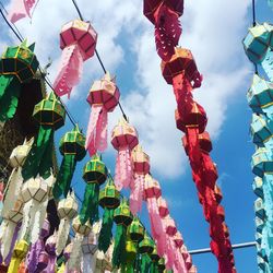 Low angle view of multi colored flags hanging against sky