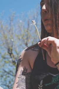 Midsection of woman holding umbrella against plants