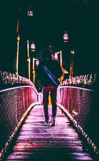 Rear view of women standing on illuminated walkway