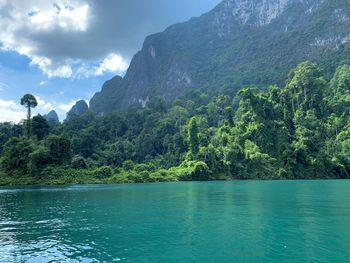 Scenic view of lake by mountains against sky