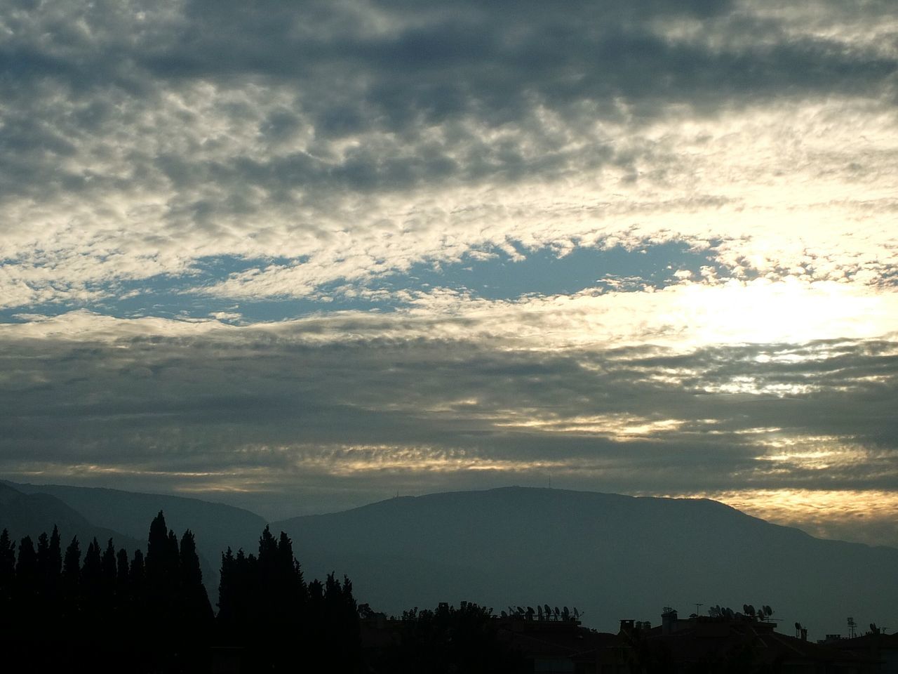 silhouette, sky, cloud - sky, scenics, tranquil scene, beauty in nature, tranquility, cloudy, sunset, nature, cloud, weather, mountain, landscape, tree, idyllic, dusk, outdoors, no people, overcast