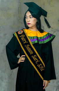 Young woman standing against wall