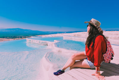 Woman on beach against blue sky