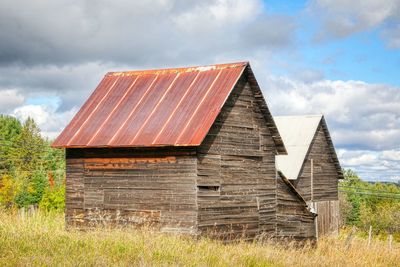 Barn on field against sky