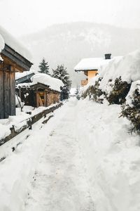 Houses on snow covered field by building