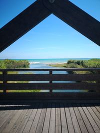 Wooden bridge over sea against clear sky