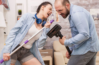 Side view of man and woman holding mobile phone