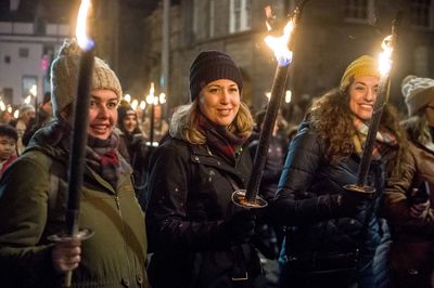 People in illuminated city at night during winter